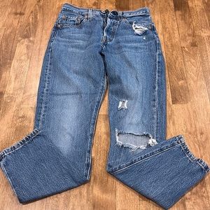 dark blue jeans with rip in the knee